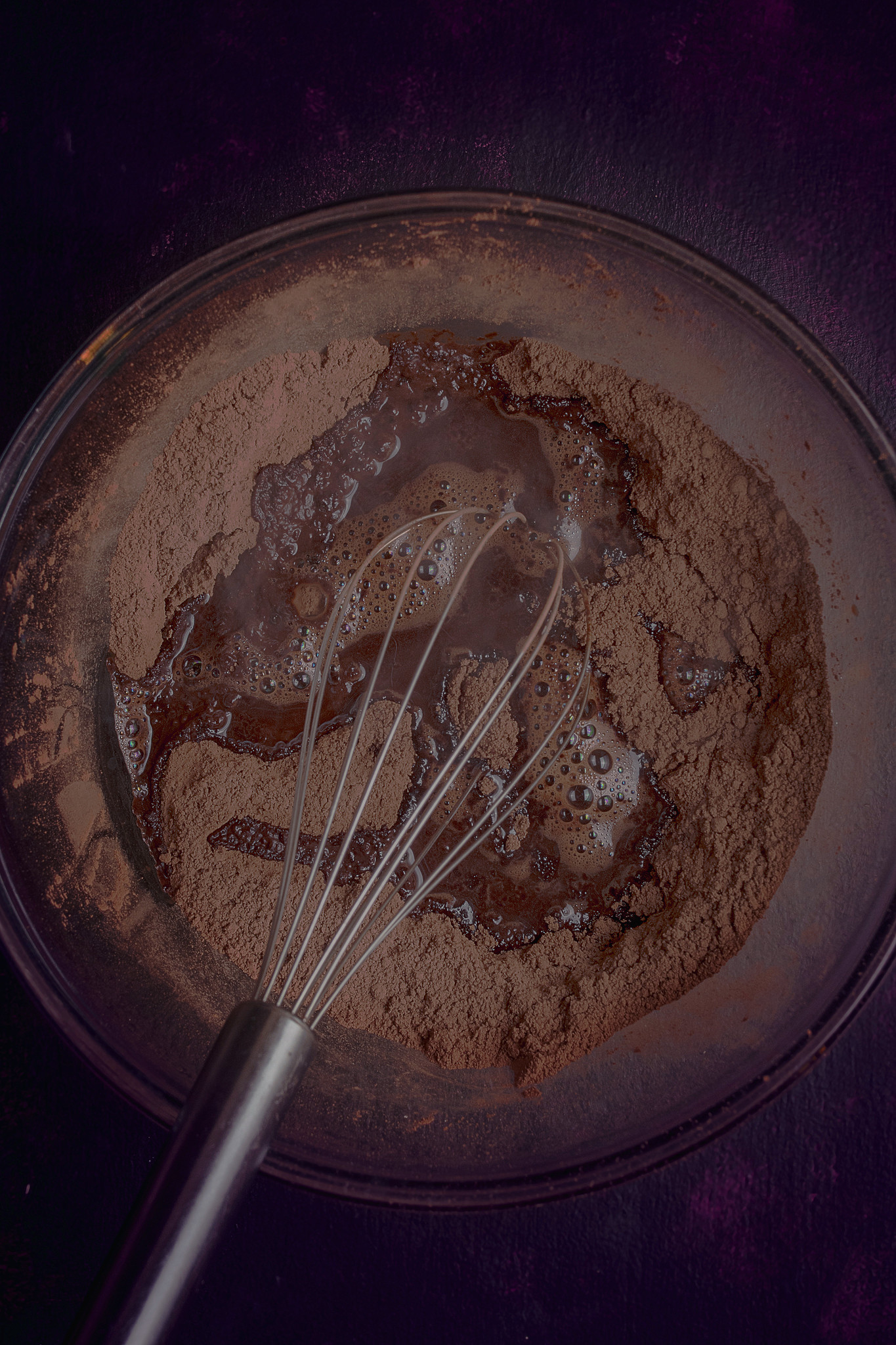 Cocoa powder, muscovado sugar and hot coffee mixture being whisked together for the chocolate cake.